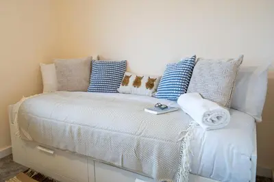 a white couch with pillows on it in a room at Cosy & Contemporary 2 Bed Home, Quiet Area Parking - Pass the Keys in Shrewsbury