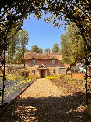 a brick building with a pathway leading to it at Cosy Cottage with Log Fire Near Hay-on-Wye in Almeley