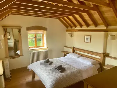 a bedroom with a bed with two towels on it at Cosy Cottage with Log Fire Near Hay-on-Wye in Almeley