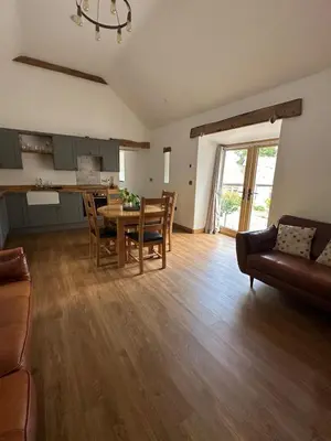 a kitchen and living room with a table and chairs at Y Sgubor Bryn Banon in Bala