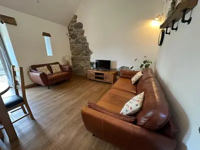 a living room with a brown leather couch at Y Sgubor Bryn Banon in Bala