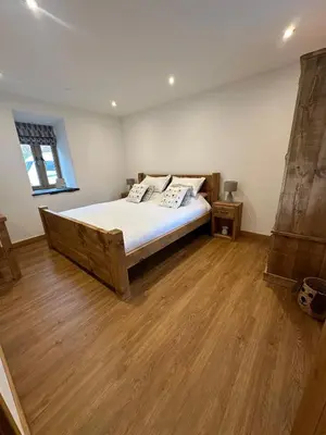 a bedroom with a bed and a wooden floor at Y Sgubor Bryn Banon in Bala
