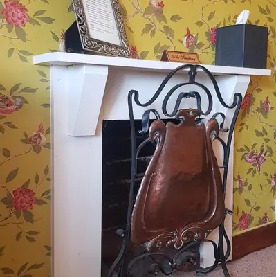 a tea kettle sitting on top of a fireplace at Victoria House in Church Stretton
