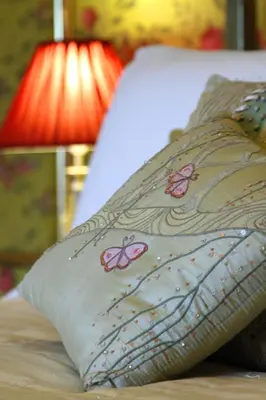 a pillow with butterflies on it sitting on a bed at Victoria House in Church Stretton