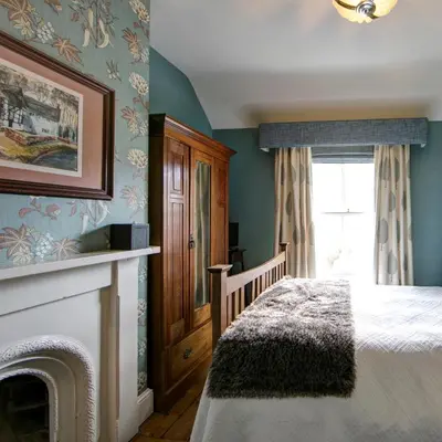 a bedroom with a bed and a fireplace at Victoria House in Church Stretton