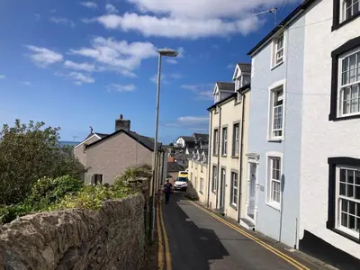 a person walking down a street next to houses at Pandy Cottage in Aberdyfi