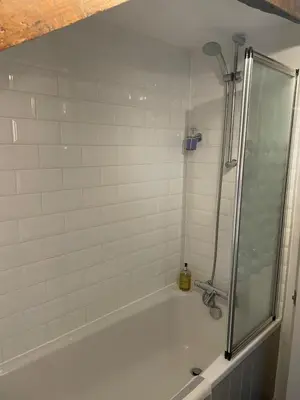 a bathroom with a shower and a tub with a sink at Cosy River Cottage in Brecon with a Fireplace in Merthyr Cynog