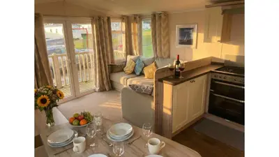 a living room with a couch and a table at Sunset Bay Aberaeron in Aberaeron