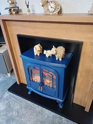a blue fireplace with two animals on top of it at The Little lodge on the lake in Welshpool