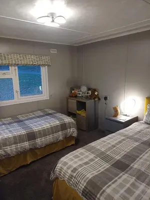 a bedroom with two beds and a window at The Little lodge on the lake in Welshpool