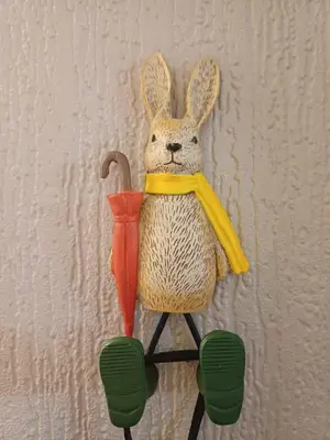 a stuffed rabbit with an umbrella on a wall at The Little lodge on the lake in Welshpool
