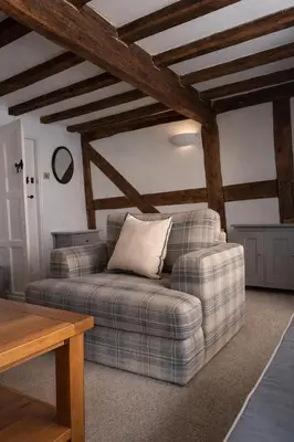 a living room with a couch and a table at Cosy Town centre Historic Tudor Cottage & parking sleeps 6 in Shrewsbury
