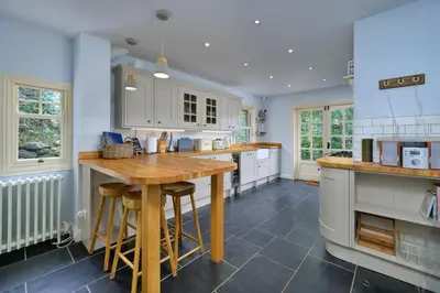 a kitchen with wooden counter tops and white cabinets at Finest Retreats - Bryn Awelon in Harlech