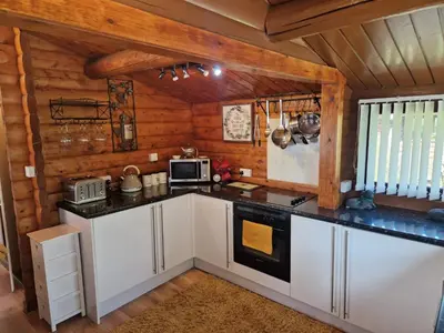 a kitchen with white cabinets and a stove at Cabin Retreat in Trawsfynydd