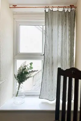 a window with a vase sitting on a table next to a chair at Arenig Cottage, a Snowdonia retreat near Lake Bala in Bala
