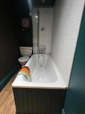 a bath tub in a bathroom with a toilet at Cosy, quirky Victorian house on Waterfall Street in Llanrhaeadr-ym-Mochnant
