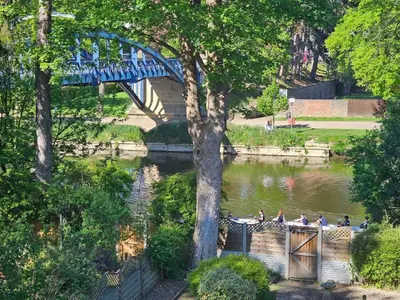 a blue bridge over a river with people on it at Ever popular 2 bedroom riverside home - to sleep 4 - Pass the Keys in Shrewsbury