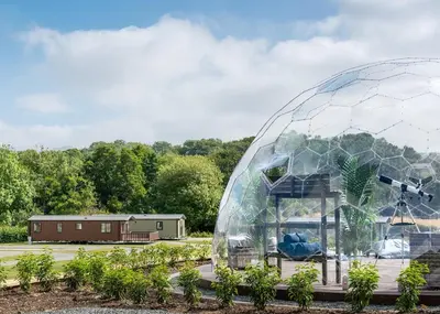 a dome greenhouse in a garden with a house in the background at Rockbridge Country Park in Presteigne