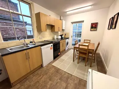 a kitchen with a table and a dining room at Victorian House in Cherry Orchard, Close to Town in Shrewsbury