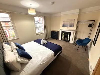 a bedroom with a large bed and a fireplace at Victorian House in Cherry Orchard, Close to Town in Shrewsbury