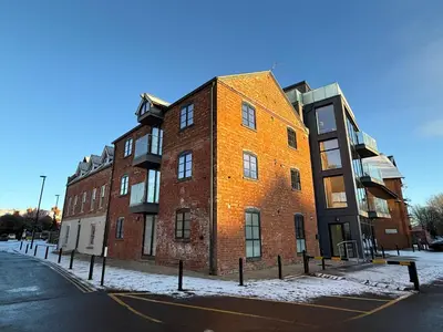 a large brick building on a city street in the snow at 3 Bed Spacious Luxury Duplex - Shrewsbury Town Centre in Shrewsbury