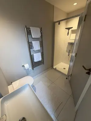 a white bathroom with a shower and a toilet at 3 Bed Spacious Luxury Duplex - Shrewsbury Town Centre in Shrewsbury