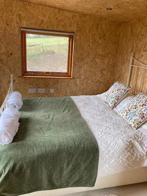 a bed in a room with a window at Bijou Cabin in Ludlow