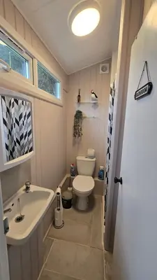 a bathroom with a toilet and a sink and a tub at Welsh Coast Seaview 2 Bedroom Wooden Lodge at Clarach Bay in Aberystwyth