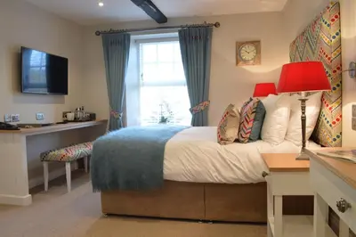 a bedroom with a bed with a window and a desk at Foyles of Glasbury in Glasbury