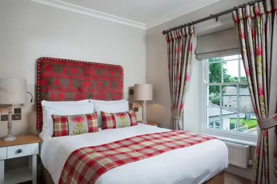 a bedroom with a bed with a red headboard and a window at Foyles of Glasbury in Glasbury