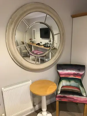 a room with a mirror and a chair and a table at Foyles of Glasbury in Glasbury