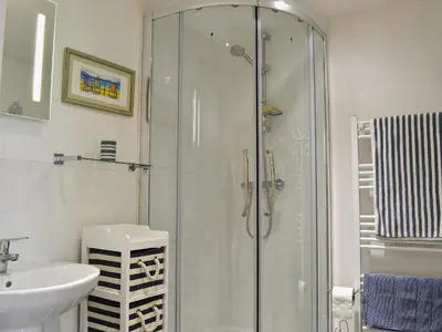 a bathroom with a glass shower and a sink at Sea View in Rhyd-y-felin