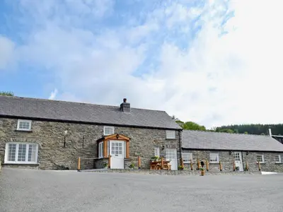 an old stone building with white doors and windows at Golygfar Mynydd - Mountain View in Strata Florida