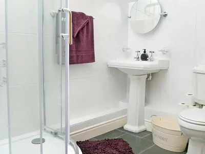 a bathroom with a sink and a toilet and a shower at Golygfar Mynydd - Mountain View in Strata Florida