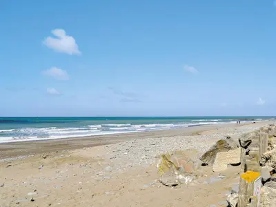 a beach with a fence and the ocean at Golygfar Mynydd - Mountain View in Strata Florida