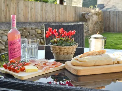a table with cheese bread and a bottle of wine at Ivy Bush Cottage in Llanddewi-Brefi