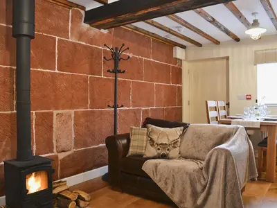 a living room with a brick wall with a fireplace at Red Lion Lodge in Myddle