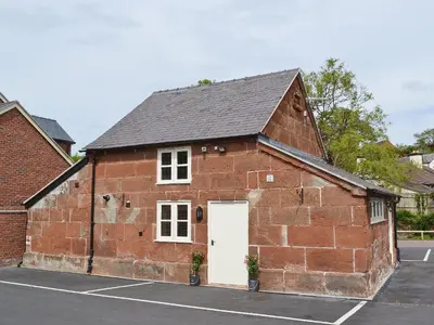 a red brick building with a white door at Red Lion Lodge in Myddle