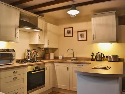 a kitchen with white cabinets and a counter top at Red Lion Lodge in Myddle