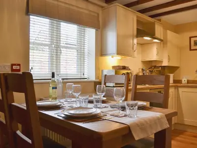 a dining room table with wine glasses on it at Red Lion Lodge in Myddle
