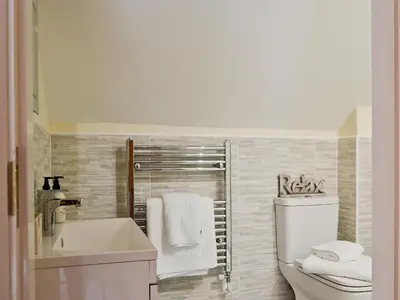 a bathroom with a sink and a toilet and a tub at Red Lion Lodge in Myddle