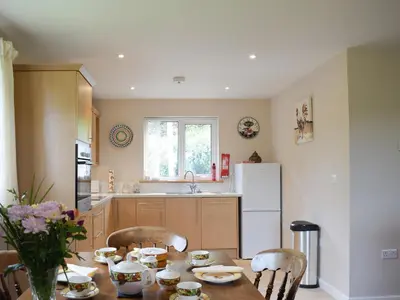 a kitchen with a table and a refrigerator at The Lodge in Presteigne