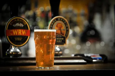 a glass of beer sitting on a bar at Y Talbot in Tregaron