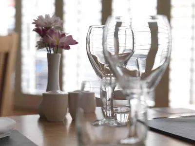 a wooden table with wine glasses and a vase with flowers at Y Talbot in Tregaron