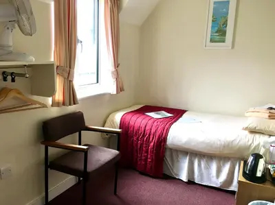 a small room with a bed and a chair at Ludlow Mascall Centre in Ludlow