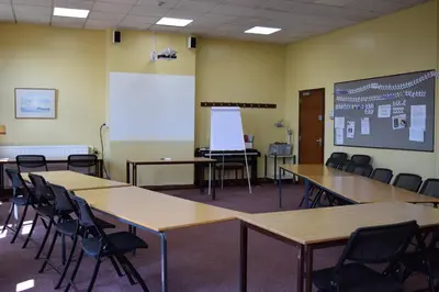 a classroom with tables and chairs and a whiteboard at Ludlow Mascall Centre in Ludlow