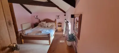 a bedroom with a bed and a wooden table at Brynderwen Barn in Llangorse