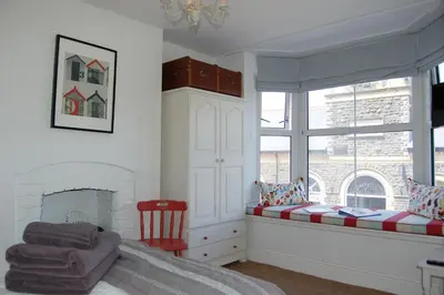 a bedroom with a bed and a window at Saint Cadfans Lodge in Tywyn