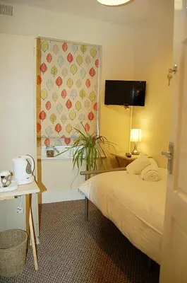 a hotel room with a bed and a window at Saint Cadfans Lodge in Tywyn