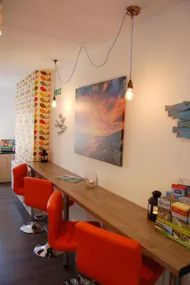 a conference room with a wooden table and orange chairs at Saint Cadfans Lodge in Tywyn